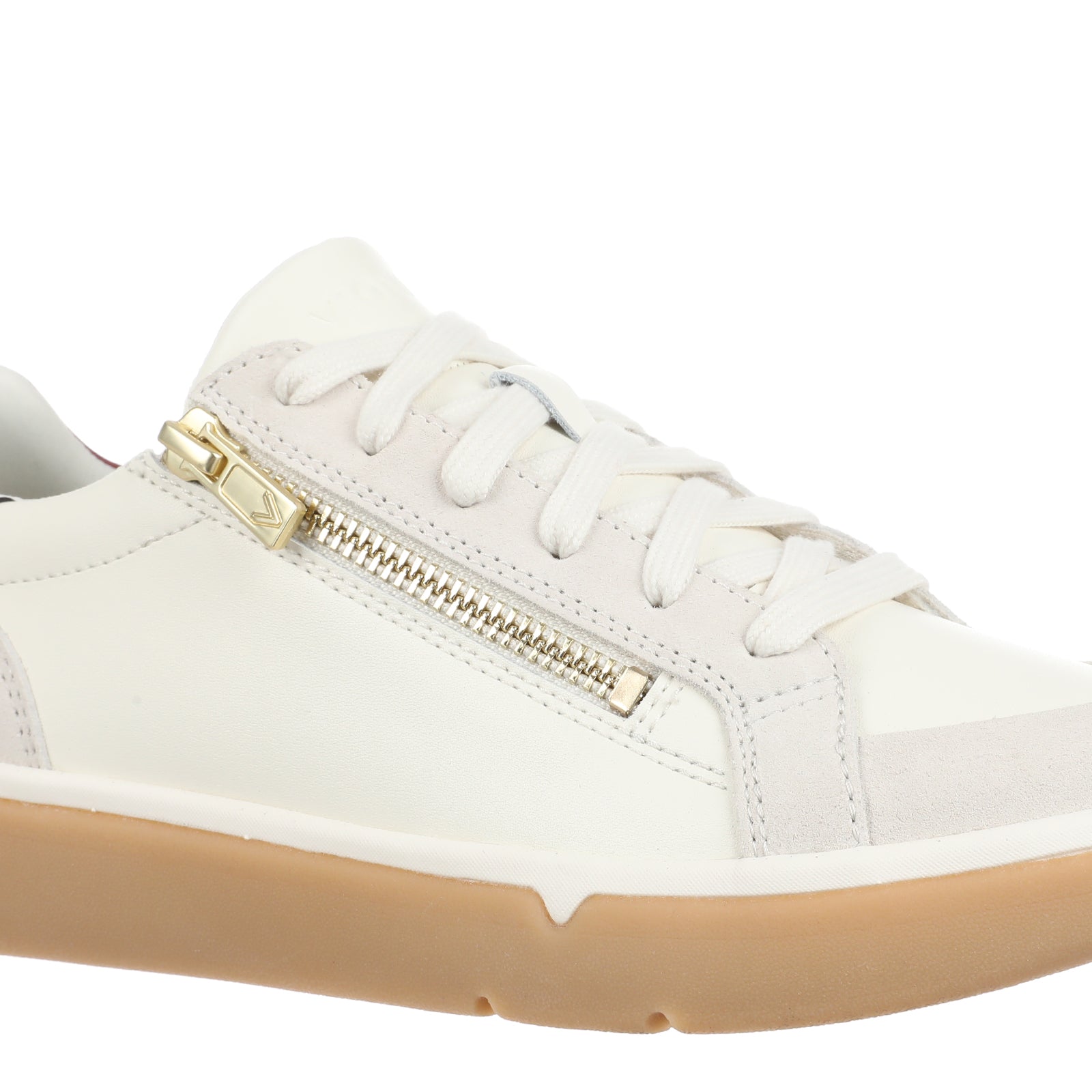 A white leather low-top sneaker with a gold-tone side zipper, white laces, a red heel tab, and a thick tan gum sole, shown against a plain white background.