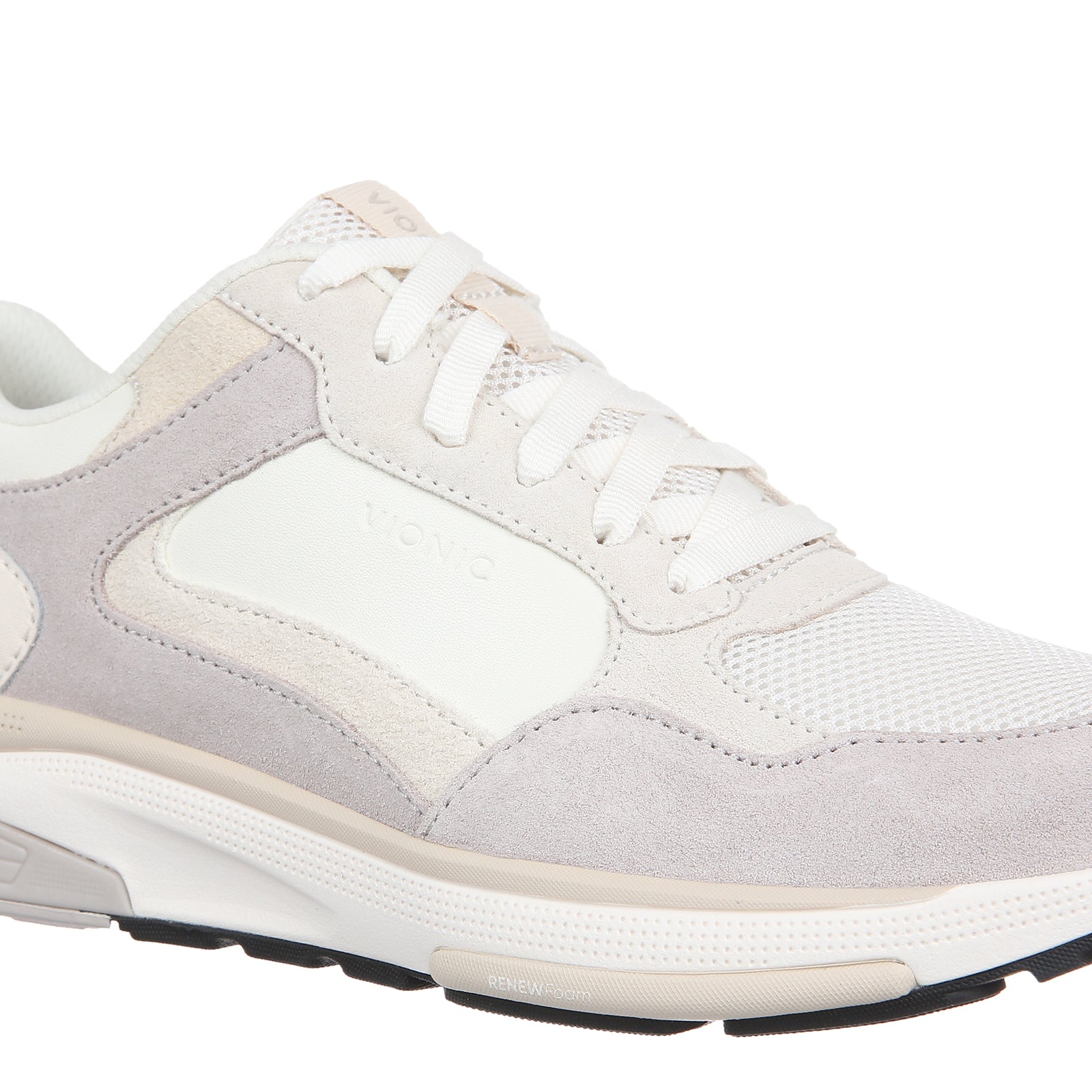 A low-top athletic sneaker in white, light gray, and beige, featuring a mesh and suede upper, white laces, and a thick white midsole with a black outsole.