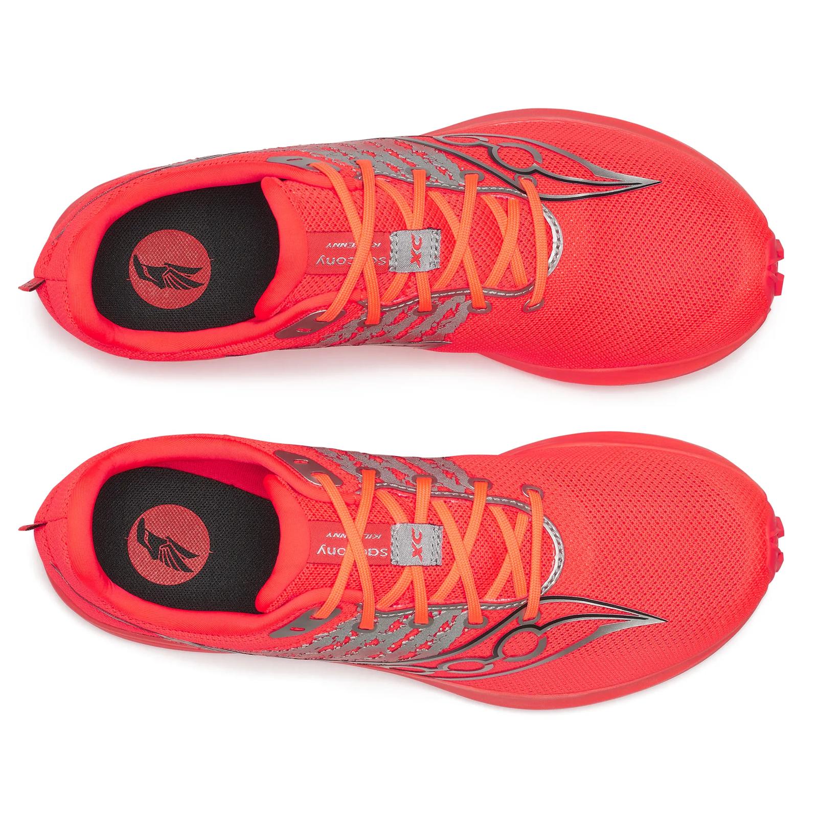Pair of red running shoes with orange laces on a white background