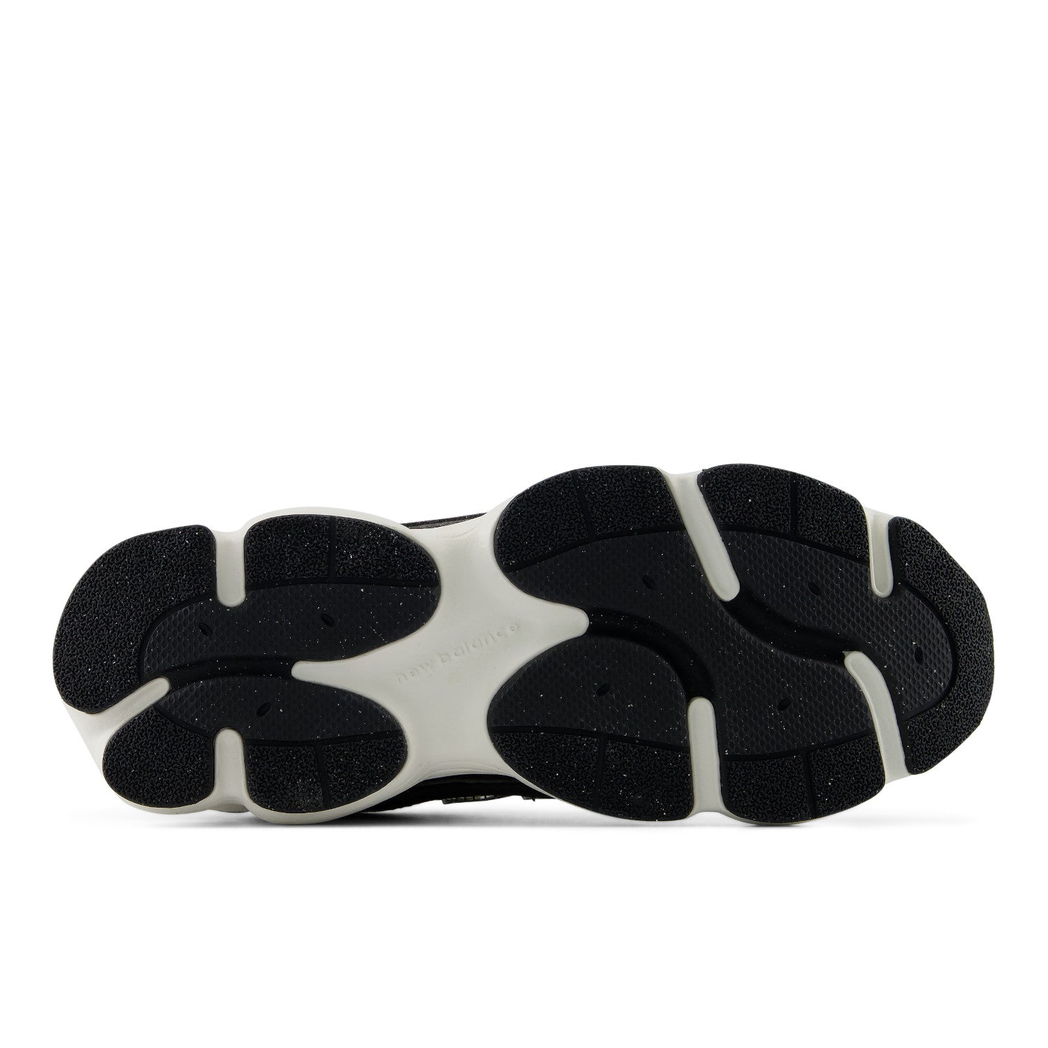A close-up bottom view of a chunky sneaker sole, showing a black textured outsole with a contrasting white midsole section.