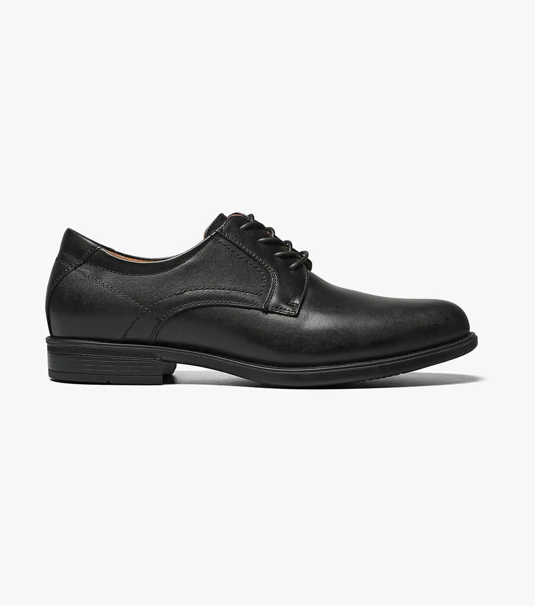 Black slip-on sneaker with white sole on a light gray background