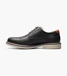 Black leather shoe with decorative elements on a white background