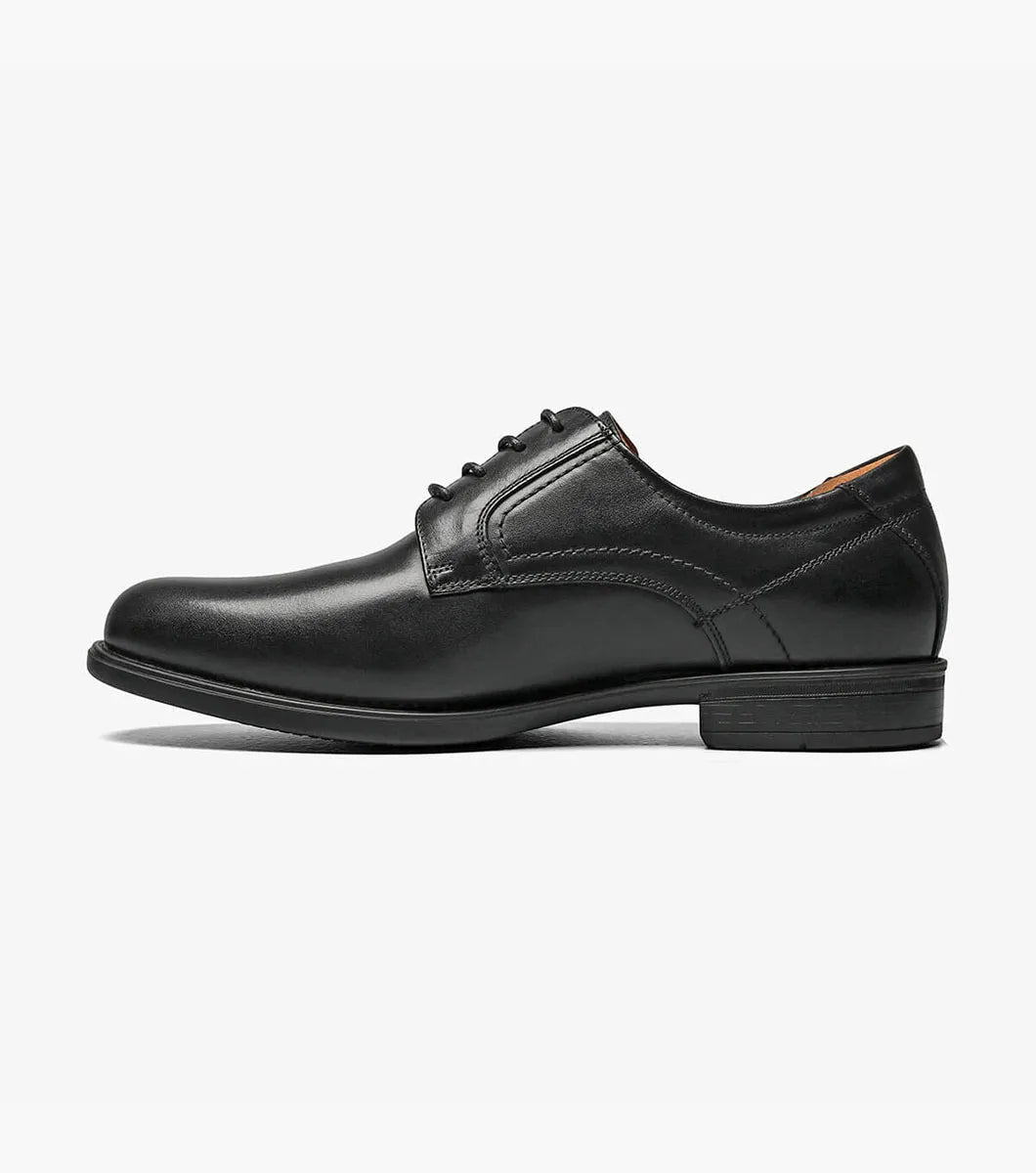 Black leather shoe with decorative elements on a white background