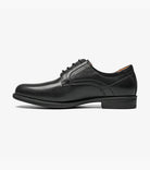 Black leather shoe with decorative elements on a white background