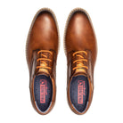 Brown leather shoes with orange laces on a white background
