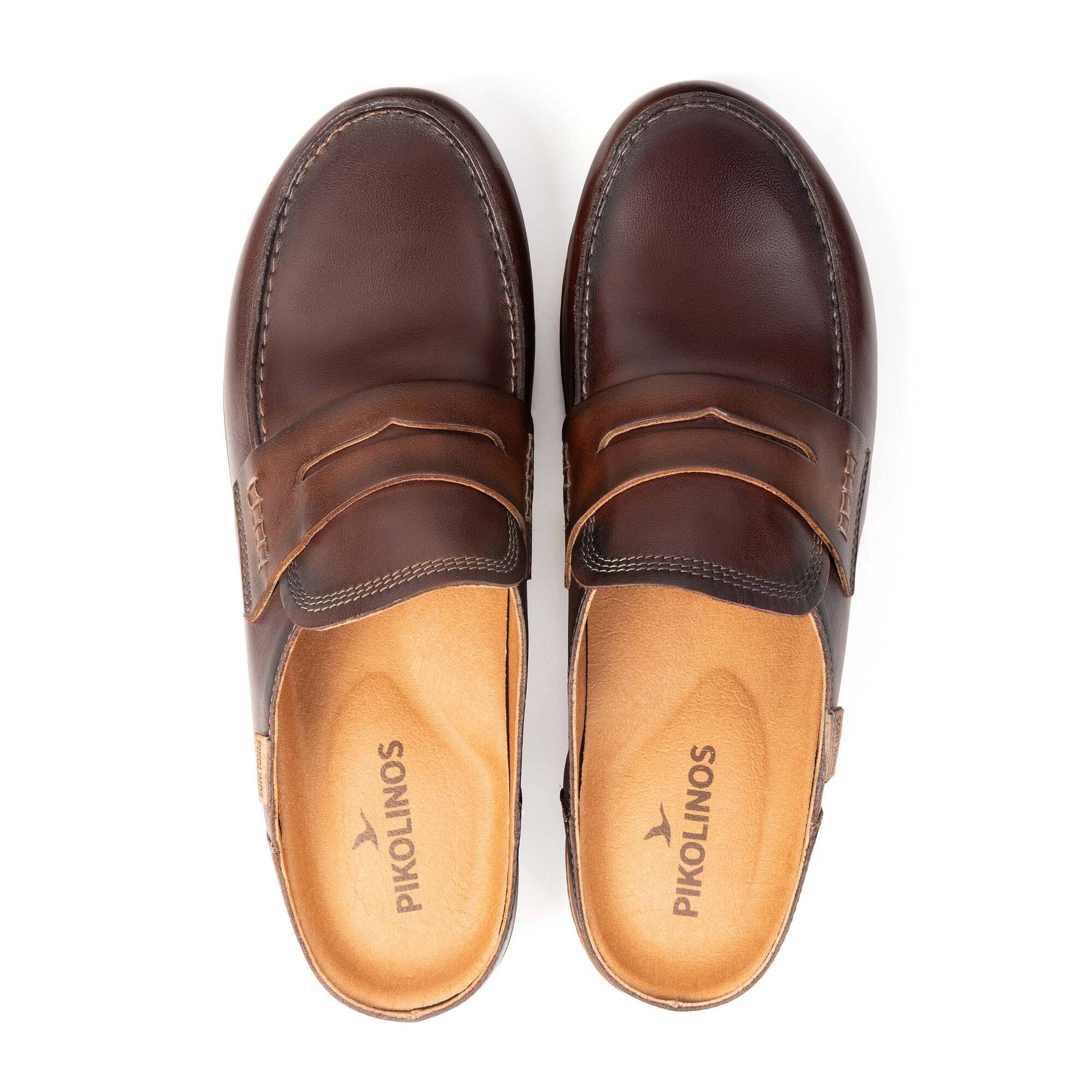 A pair of dark brown leather penny loafers shown from a top-down view on a white background. The brand name 'PIKOLINOS' is printed on the tan insoles.