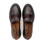 A pair of dark brown leather penny loafers with a darker burgundy strap, shown from a top-down view on a white background. The brand name 'PIKOLINOS' is printed on the tan insoles.