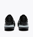 Black running shoes shown from the rear, featuring a textured black upper, white and gray geometric side accents, and a thick white and black midsole, set against a plain white background.