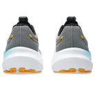 Gray and yellow running shoes with white soles on a white background