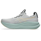 Gray running shoe with a light green sole on a white background