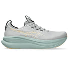 Gray running shoe with a light green sole on a white background