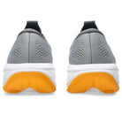 Gray running shoes with yellow soles on a white background
