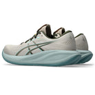 Light gray and teal running shoe on a white background