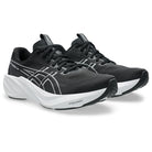 Black running shoes with green accents on a white background
