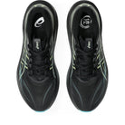 Black running shoes with green accents on a white background
