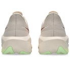 Pair of beige and gray slip-on shoes with green accents on a white background