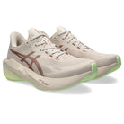 Beige running shoes with green accents on a white background