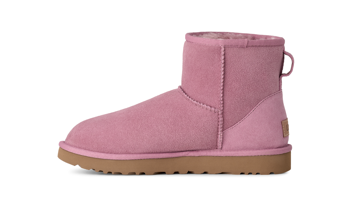 A single pink suede ankle boot with a tan sole, shown in a side profile on a solid white background.