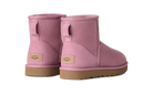A pair of UGG mini boots in dusty pink suede with tan soles, shown from the back on a clean white background.