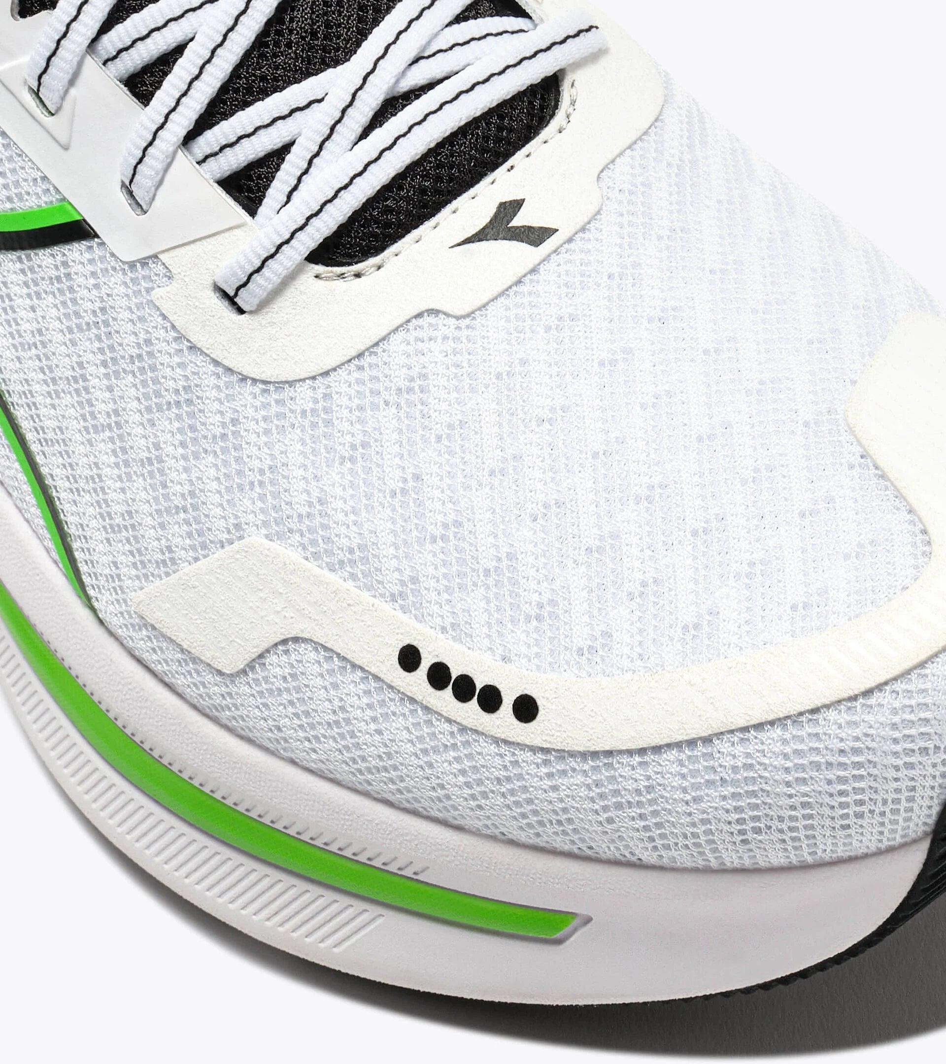 Close-up of a white athletic shoe with green accents on a white background