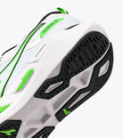 Close-up of a white athletic shoe with green accents on a white background