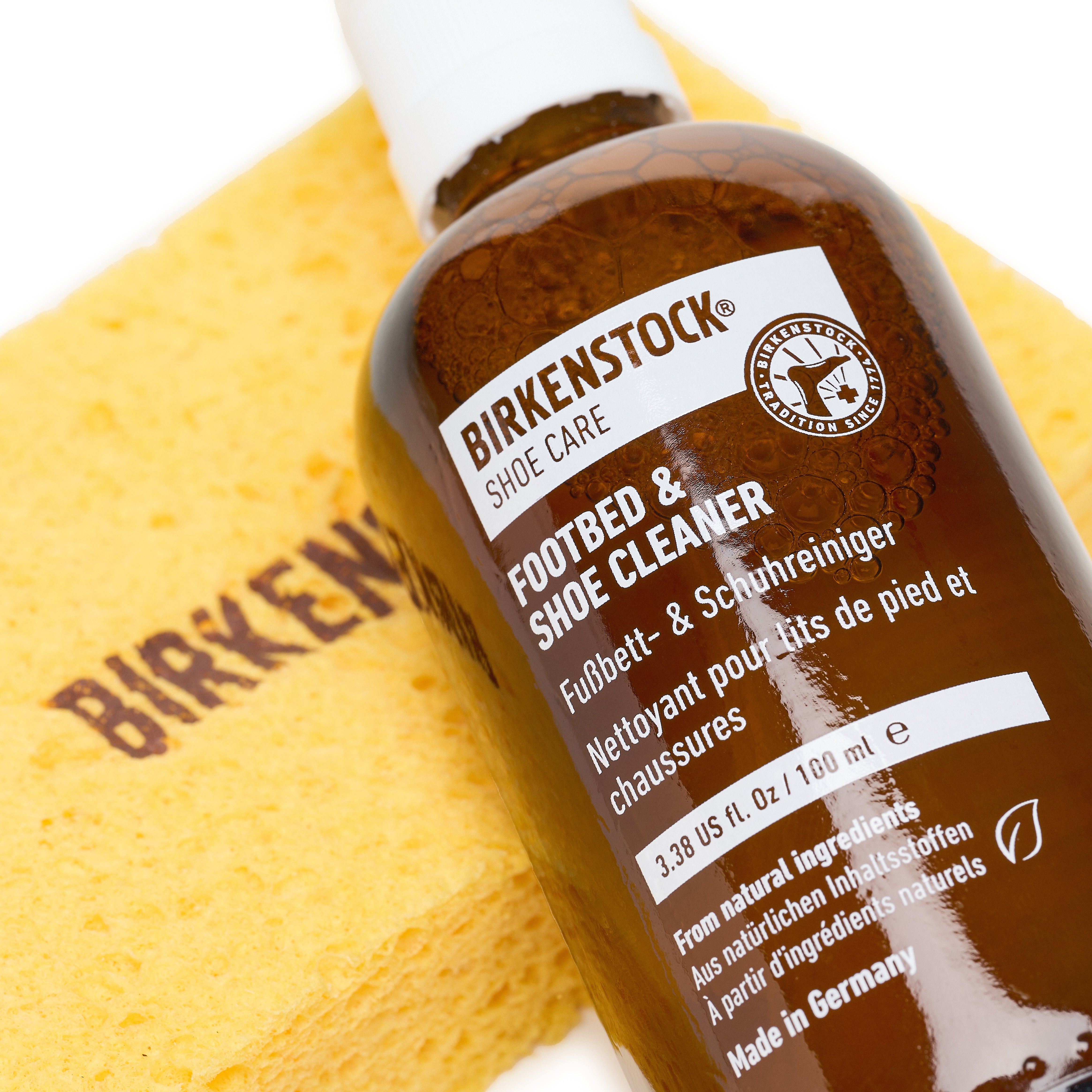 Birkenstock footbed and shoe cleaner bottle with a yellow sponge on a white background