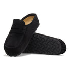 Black loafers with a textured sole on a white background