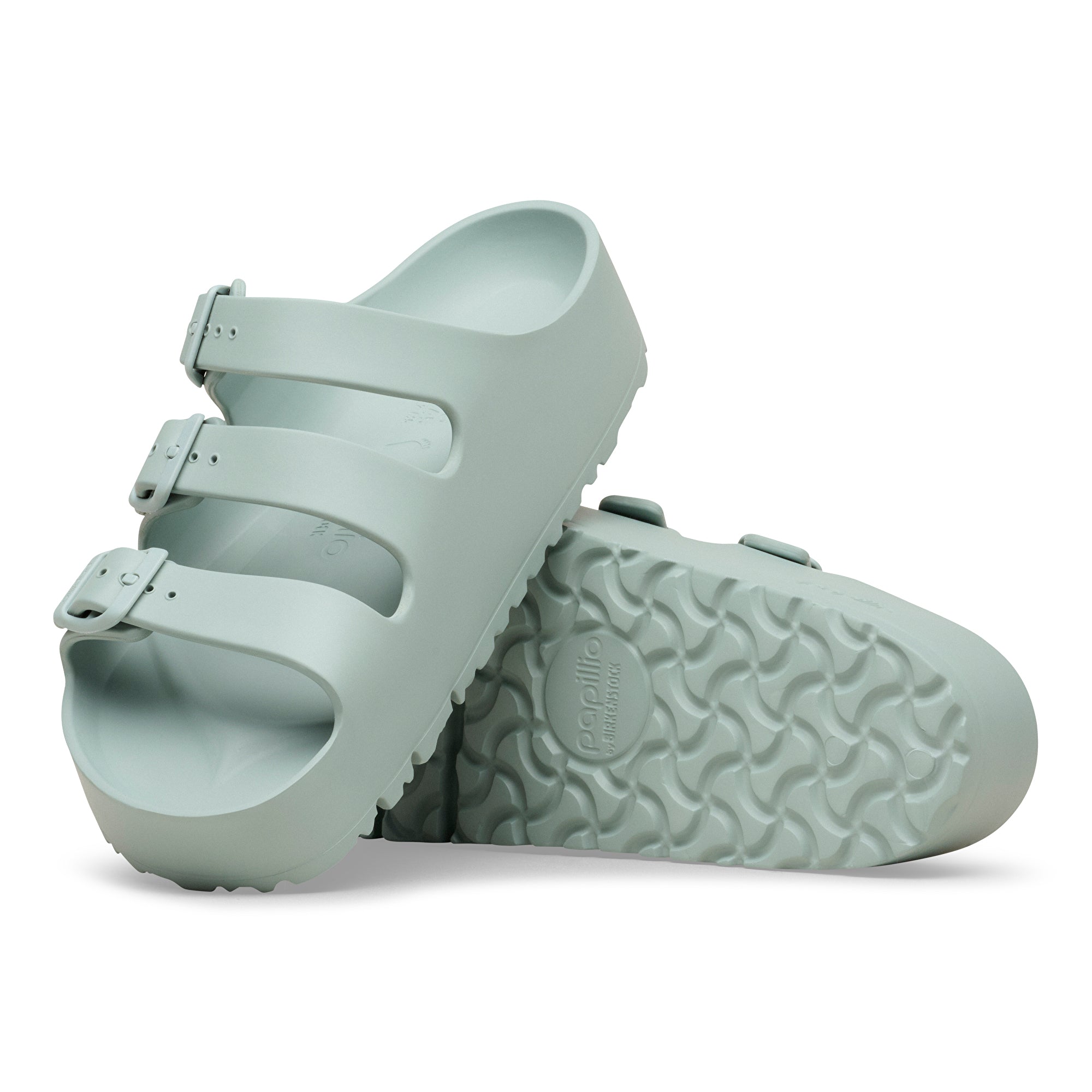 Pair of light green sandals on a white background