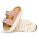 Pair of pink sandals with white soles on a white background