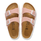 Pair of pink sandals with metallic buckles on a white background