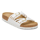 White sandal with gold buckles on a white background