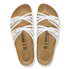 White sandals with brown soles and Birkenstock branding on a white background