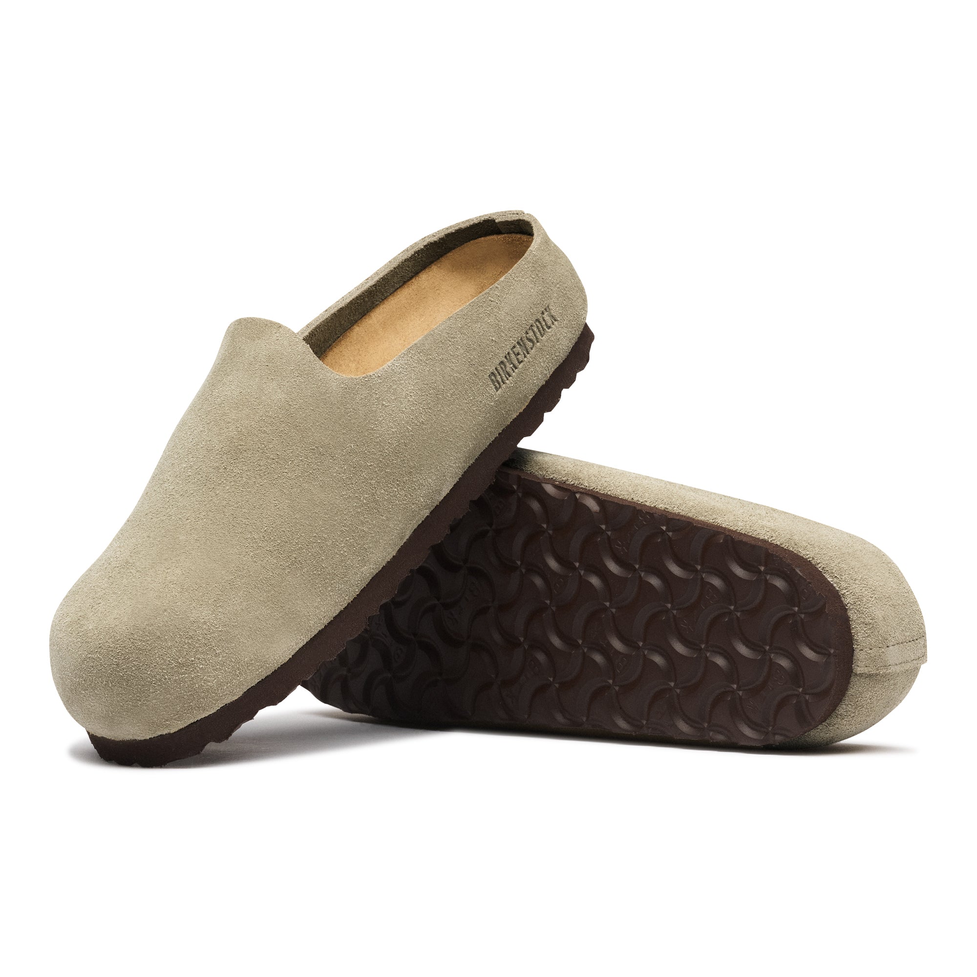 Pair of beige slippers with brown soles on a white background