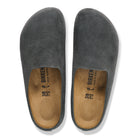 Pair of gray slippers with brown soles on a white background