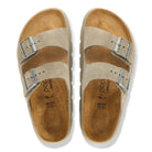 Pair of tan sandals with metallic buckles on a white background