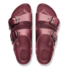 Pair of maroon sandals with buckles on a white background