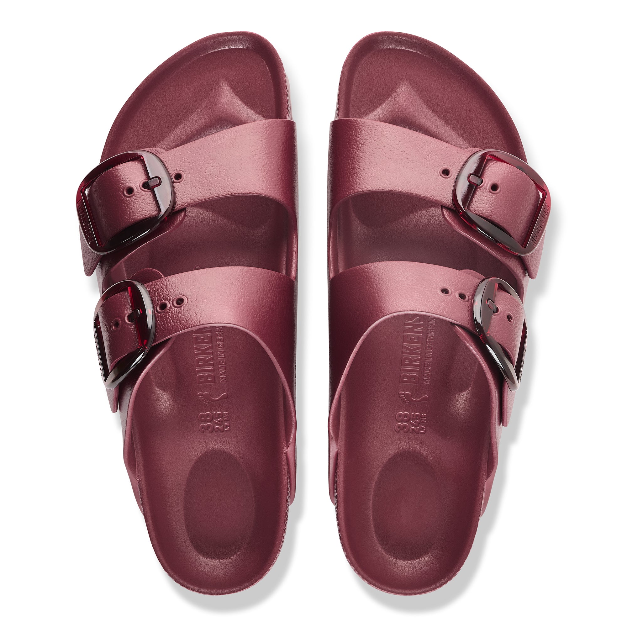 Pair of maroon sandals with buckles on a white background