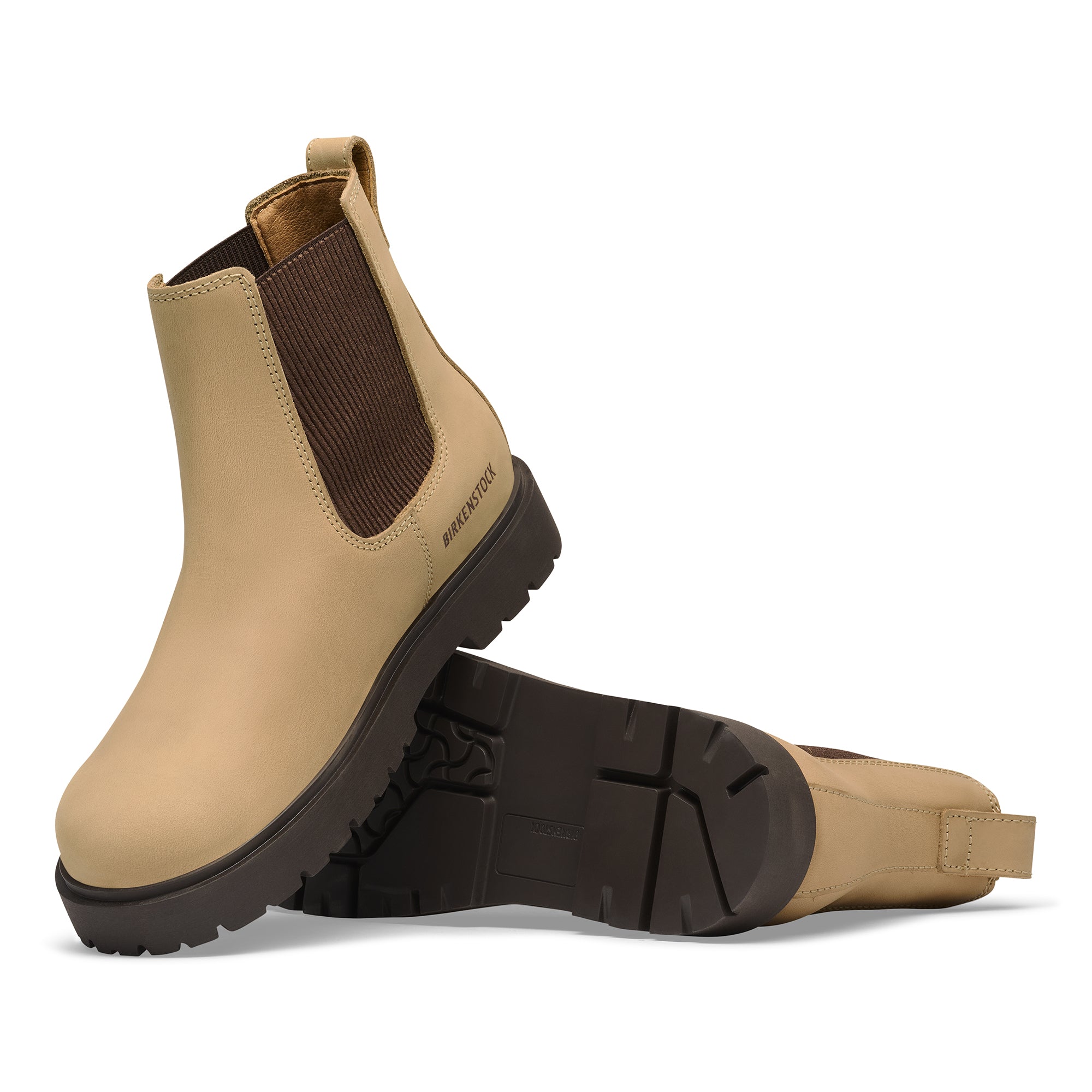 Tan Chelsea boots with brown accents on a white background