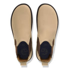 Pair of tan Chelsea boots with brown accents on a white background