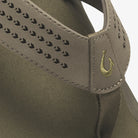 Close-up of a gray shoe with a brand logo on a white background