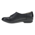 Black flat shoe with gold buckle on a white background