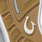 Close-up of a shoe sole with a logo on a brown background