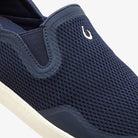 Navy slip-on shoe with mesh design and white sole on a light gray background