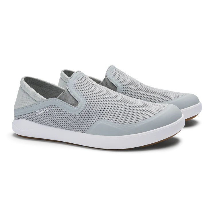 Pair of light gray slip-on shoes with white soles on a white background