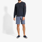 Person wearing a black long-sleeve shirt and gray shorts on a white background