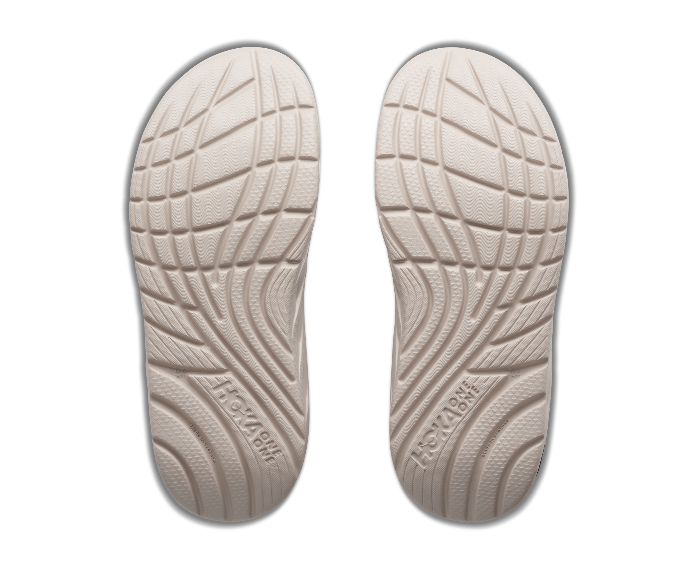 Pair of beige shoe insoles with tread pattern on a white background