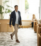 Man walking in a modern office setting with plants and furniture.