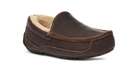 A single dark brown leather slip-on moccasin-style shoe with a light beige sherpa lining, shown from a three-quarters angle on a white background.