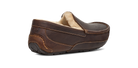 A dark brown leather driving loafer slipper with a soft beige shearling lining, shown from a three-quarters rear angle on a white background.