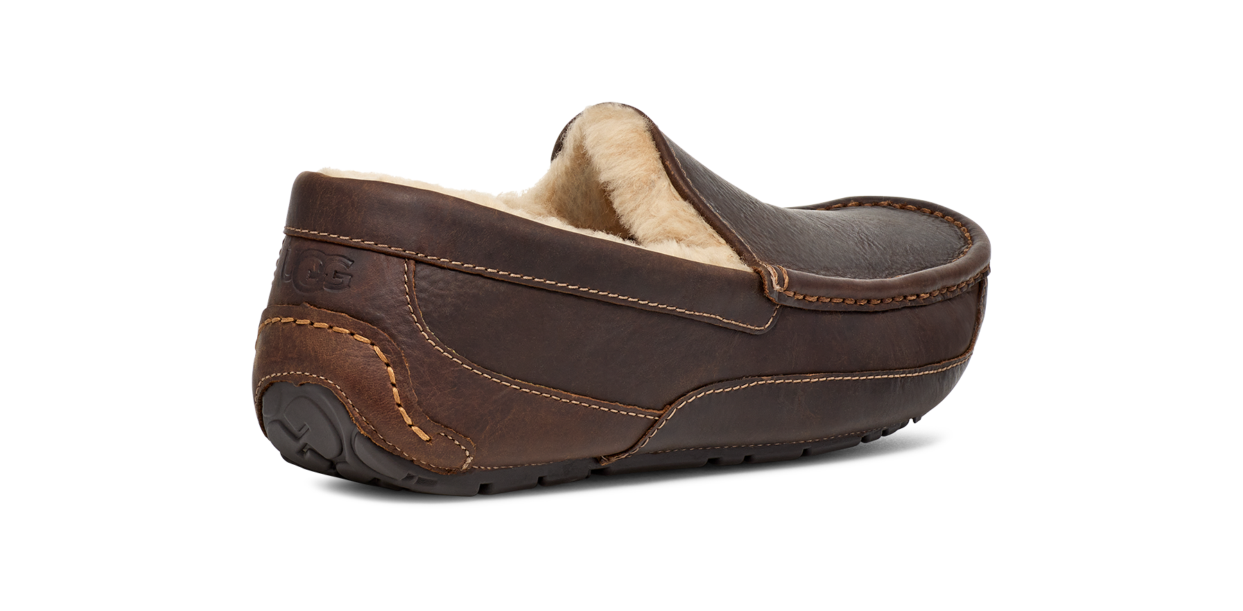 A dark brown leather driving loafer slipper with a soft beige shearling lining, shown from a three-quarters rear angle on a white background.